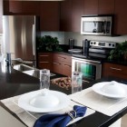 Dwellatvue Apartment Wooden Attractive Dwellatvue Apartment Kitchen With Wooden Drawers And White Backsplash Near White Island And Dark Countertop Decoration Amazing Elegant Dwelling For Fantastic Modern Home Tour