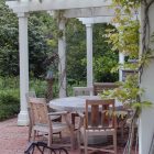 Patio Pergola White Eccentric Patio Pergola With Round White Dining Table And Wood Armchairs Tall Pillars Shady Greenery Antique Outdoor Light Outdoor Elegant Terrace With Natural Patio Pergola For The Modern Homes