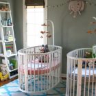 White Painted Baby Luxurious White Painted Oval Best Baby Cribs Coupled With Ladder Styled Storage To Display Colorful Items Kids Room Marvelous Best Baby Cribs Designed In Twins Model For Small Room