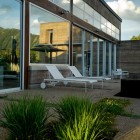 Terrace Outside Residence Sensational Terrace Outside The Lord Residence With White Beach Benches And Brown Floor Near Reflective Glass Windows Architecture Unique Pond House Design For Your Private Relaxing Place