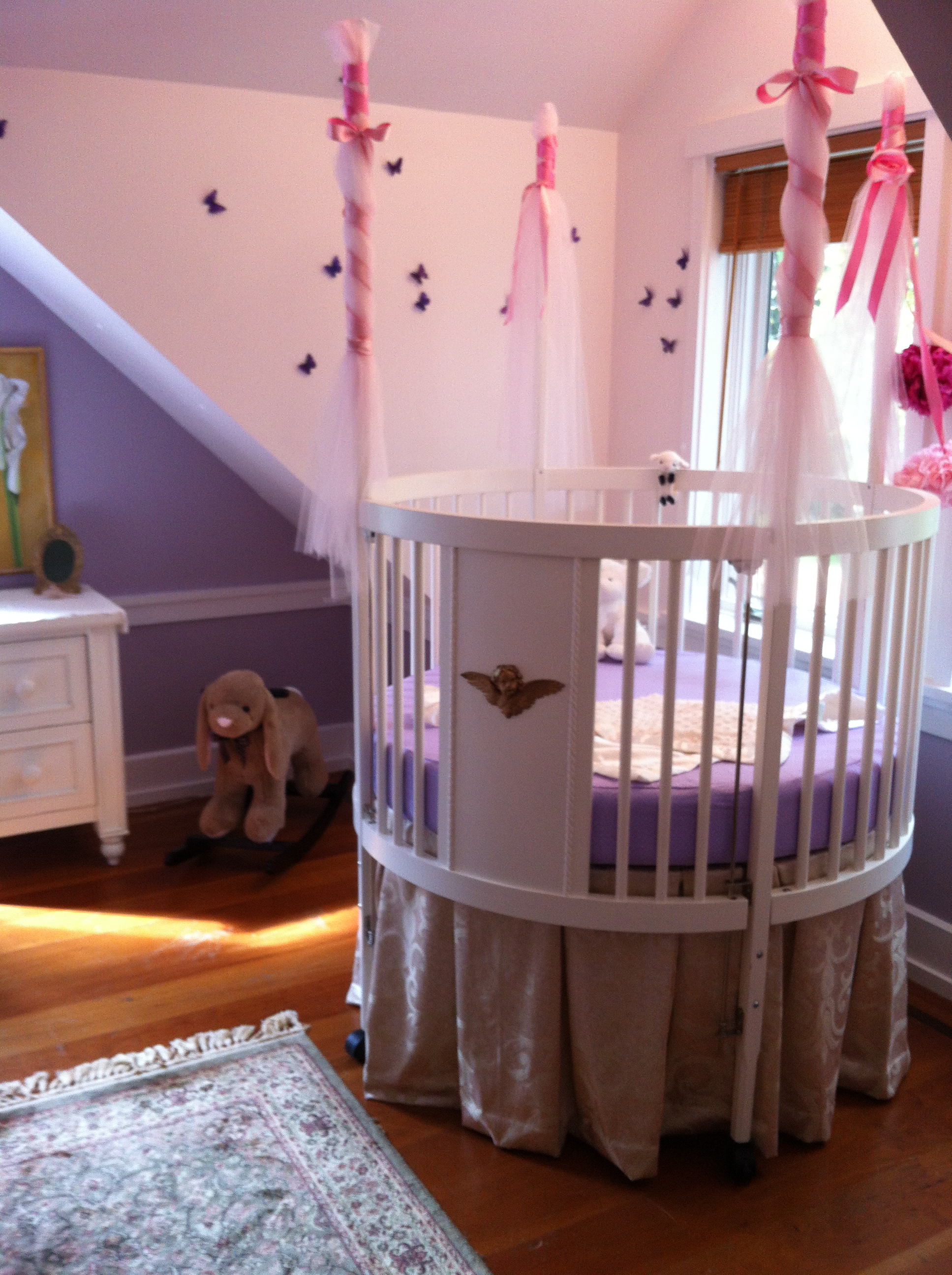 White Round Completed Cute White Round Crib Idea Completed With Purple Mattress And Metallic Skirt With Net And Pink Ribbon On Posts Kids Room Adorable Round Crib Decorated By Vintage Ornaments In Small Room