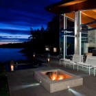 Sunset And Warm Mesmerizing Sunset And Beach View Warm Outdoor Fireplace Tough Metallic Chairs Glass Wall Sloping Roof Shiny Outdoor Lights Architecture Stunning Waterfront House With Lush Forest Landscape