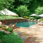 Backyard Landscape Vegetations Naturally Backyard Landscape With Lush Vegetation And Granite Tile Outdoor Flooring Decorated With Outdoor Wooden Chairs Swimming Pool Amazing Cool Swimming Pool Bringing Beautiful Exterior Style