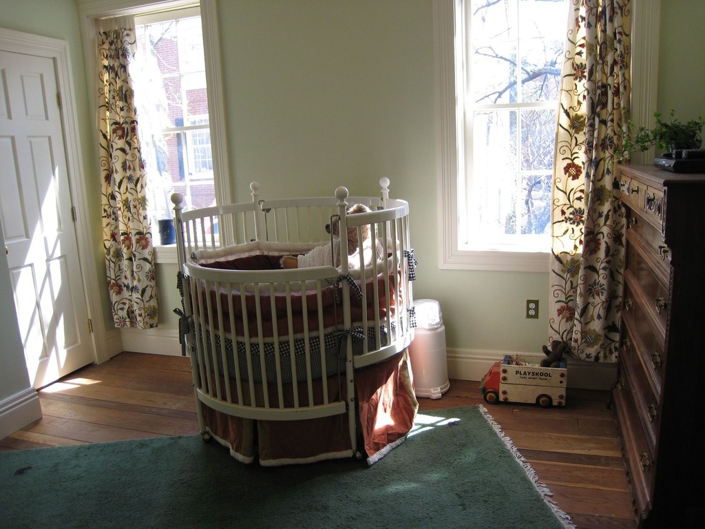 White Painted With Traditional White Painted Round Crib With Maroon Skirt Contrasted By Floral Patterned Curtain On Windows Kids Room Adorable Round Crib Decorated By Vintage Ornaments In Small Room