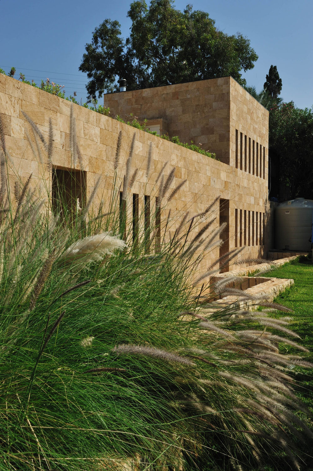 Grassy Yard Plants Freshening Grassy Yard And Ornamental Plants At Fidar Beach House In Modern Architecture Tough Stone Outdoor Wall Dream Homes  Futuristic Modern Beach House With Neutral Color Palettes For A Family Of Five