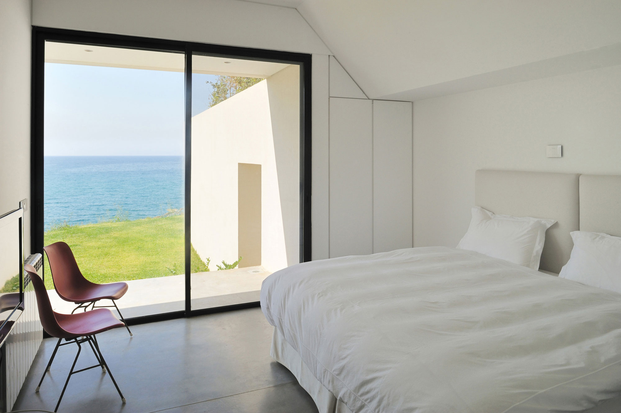 White Bed Chairs Modern White Bed Red Acrylic Chairs Glass Door In Dark Frame Concrete Floor Appealing Beach View Fidar Beach House Dream Homes Futuristic Modern Beach House With Neutral Color Palettes For A Family Of Five