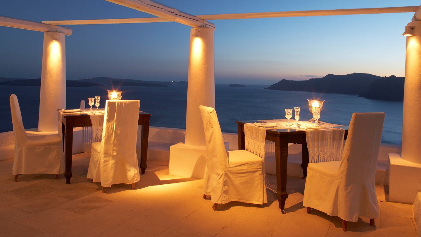 Outdoor Dining Katikies Romantic Outdoor Dining Area At Katikies Hotels In Oia With Dramatic Lighting Decorated Wit Fabric White Chairs Interior Design Classy And Elegant White Home With Breathtaking Panoramic Sea Views