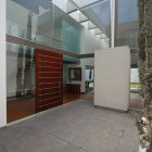 Entrance Of Residence Wide Entrance Of The Patio Residence With Wooden Door And Stone Floor Near The Glass Walls Dream Homes Stunning White Home With Authentic Patio In Modern Style