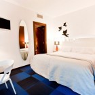 Bedroom Area And Neat Bedroom Area With Mirror And White Chair Feat Table Beside The Lamps At The Hotel Portago Urban Decor Hotels & Resorts Bright Modern Interiors With Vibrant Pops Of Colors For Hotels