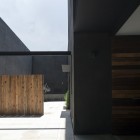 Minimalist Garden Plants Beautiful Minimalist Garden With Ornamental Plants In Concrete Planters Tall Dark Concrete Wall Rustic Wood Fence Small Cantilever Dream Homes Dramatic Home Decoration With Black Painted Exterior Walls