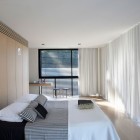Bed With Lacquered Comfortable Bed With Striped Bed Sheet Lacquered Wood Wardrobe Sheer White Drape Wood Floor Small Wood Bar Stools Wall Mounted Desk In Luff Residence Architecture Astonishing Contemporary Concrete Home With Minimalist Interior Features