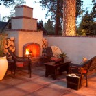 Outdoor Fireplace The Imposing Outdoor Fireplace Designs At The Afternoon That Wooden Table Feat Planters And Trees Surrounding The Area Decoration Classic Outdoor Fireplace Designs For Impressive Exterior Decoration