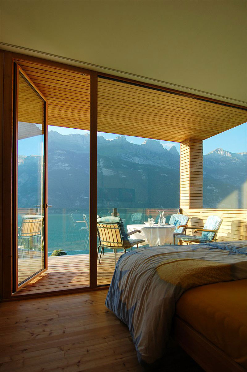 Bedroom Design Am Marvelous Bedroom Design Of Wohnhaus Am Walensee Residence With Brown Bed Linen Blue Blanket And Transparent Wall Made From Glass Panel Architecture  Beautiful Rectangular Lake Home With Wood And Concrete Elements