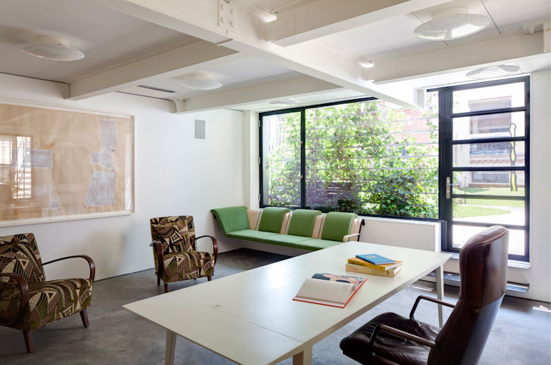 Home Office Artist Simple Home Office Inside The Artist Residence With Long Desk And Brown Swirly Chair On Concrete Floor Decoration Elegant Home Decorated With Artistic And Contemporary Living Spaces