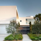 White Garage Modern Wide White Garage Door In Modern Family Residence Facade With Grey Gate And White Wall Near Green Plantations Dream Homes Duplex Contemporary Concrete Home With Outdoor Green Gardens For Family