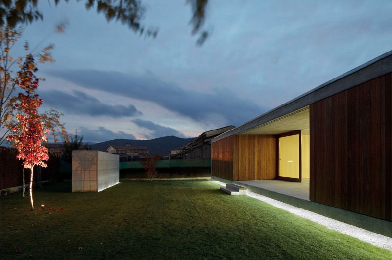 Lighting From In Bright Lighting From The House In Villarcaya With Concrete Terrace And Green Grass Yard Near Wooden Wall Architecture Chic Spanish Home Design With Grey Concrete Floors