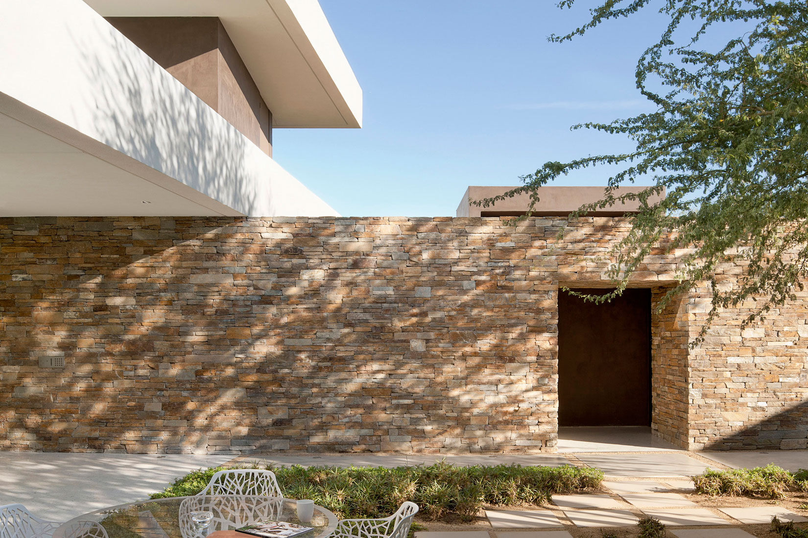 Stone Wall Chairs Great Stone Wall Outdoor White Chairs Round Glass Table Concrete Path Madison House In Modern Contemporary Dream Homes Spectacular And Spacious Contemporary House With Sliding Glass Walls