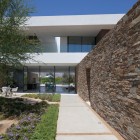 Stone Wall Colorful Rough Stone Wall Concrete Path Colorful Flowers On Modern Garden Glass Door White Chairs Open Plan Interior In Madison House Dream Homes Spectacular And Spacious Contemporary House With Sliding Glass Walls