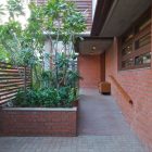Ornamental Plants Flower Beautiful Ornamental Plants In Rectangular Flower Bed In Green House Rustic Brick Wall Shiny Outdoor Light Traditional Wood Gate Interior Design Eco-Friendly Modern Green Home With Exposed Red Brick Walls
